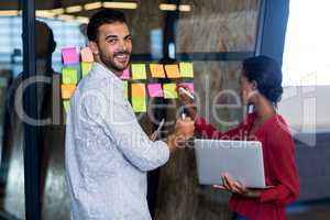 Colleagues writing on sticky notes