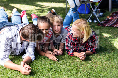 Family relaxing outside their tent