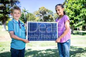 Siblings holding a solar panel