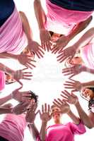 Women in pink outfits standing in a circle for breast cancer awa