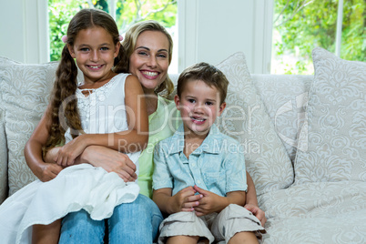 Portrait of mother with daughter and son on sofa