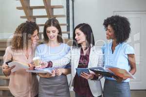 Female business colleagues standing together with file and digit