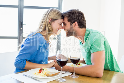 Young couple sitting face to face at dinning table