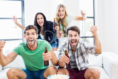 Excited friend holding beer bottles