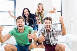 Excited friend holding beer bottles