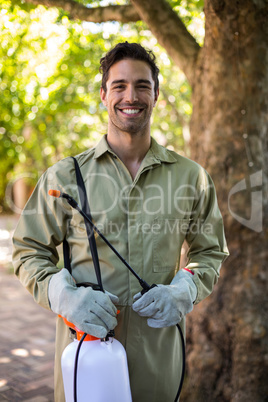 Portrait of happy worker with insecticide sprayer