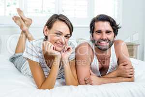 Happy couple lying on bed at home