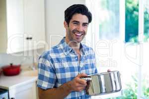 Portrait of young man preparing food in kitchen