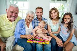 Happy multi-generation family sitting on sofa at home