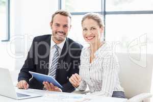 Colleagues using a digital tablet at desk