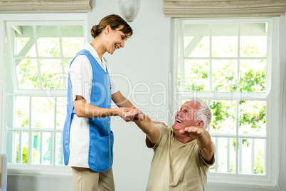 Happy nurse and senior man at health club