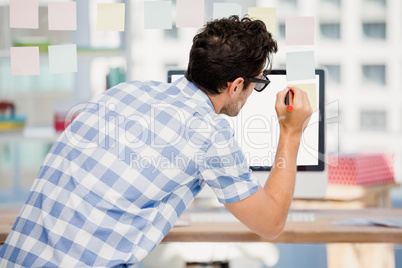 Rear view of man writing on sticky notes