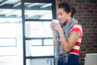 Beautiful woman smelling a cup of coffee