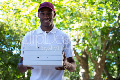 Happy delivery man holding pizza boxes