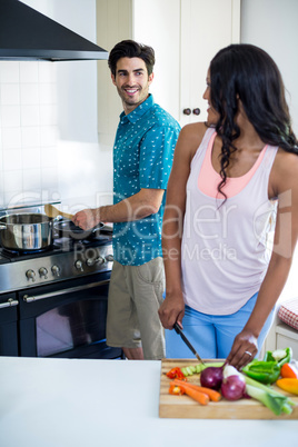 Young couple cooking food together in kitchen