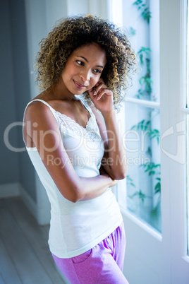 Thoughtful young woman standing near the window