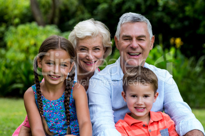 Smiling grandparents with grandchildren at yard