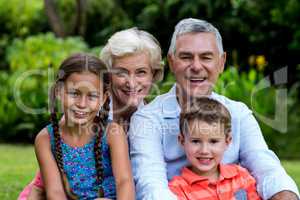 Smiling grandparents with grandchildren at yard