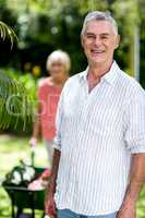 Senior man standing against woman at yard