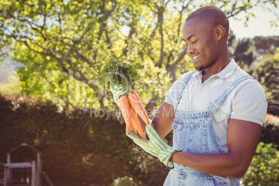 Young man holding bunch of carrots