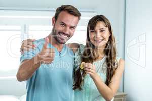 Smiling couple with key at new house