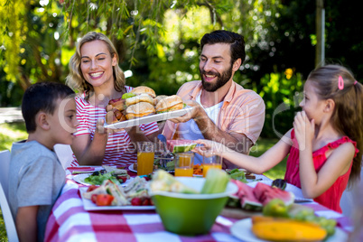 Happy family having meal in yard