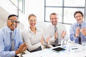 Businesspeople applauding while in a meeting