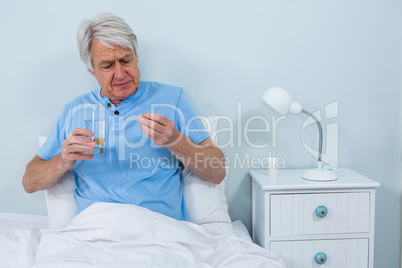 Senior man taking pills at home