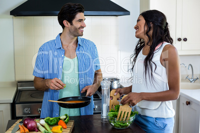 Young couple cooking food together in kitchen