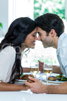 Young couple holding hands and sitting face to face