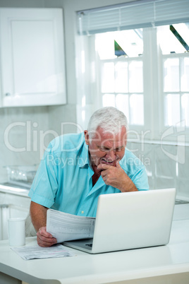 Smiling man looking into laptop