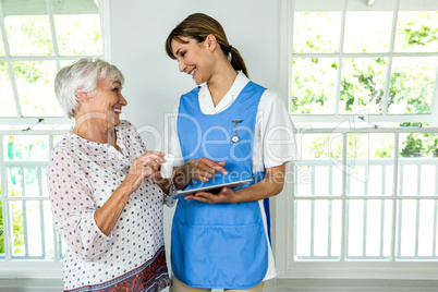 Smiling senior woman standing with nurse