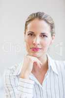 Happy businesswoman sitting with hand on chin