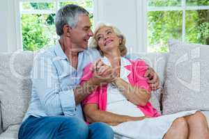 Loving senior couple looking at each other in living room