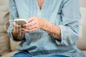 Midsection of senior woman using mobile phone