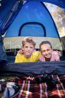 Siblings lying in a tent