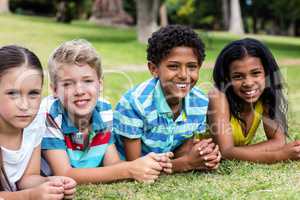 Happy children lying on grass