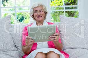 Portrait of senior woman holding digital tablet