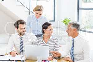 Business colleagues discussing office work on laptop