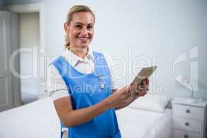 Portrait of confident nurse holding digital tablet