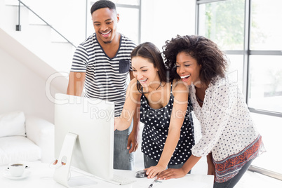 Businesspeople looking at computer and smiling