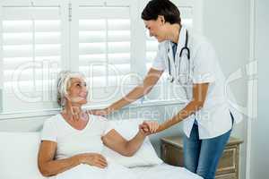 Female doctor assisting old woman