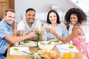 Friends toasting wine glasses while having a meal