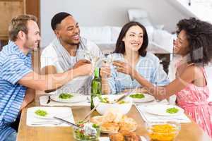 Friends toasting wine glasses while having a meal