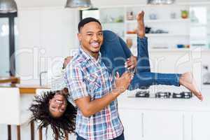 Man lifting his woman in kitchen