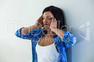 Tensed woman leaning on wall