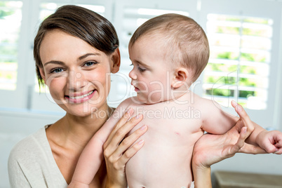 Mother smiling while carrying son at home