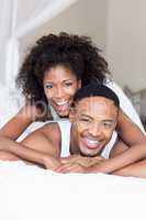 Young couple lying on bed and embracing each other