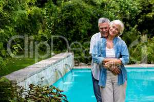 Loving senior man embracing wife from behind while standing at p