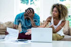 Worried young couple discussing on bills